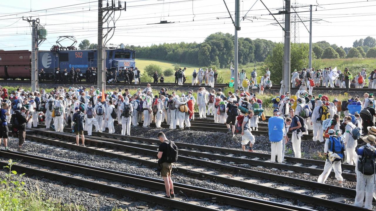 Aktivisten stehen auf den Gleisen der Kohle-Transportbahn und blockieren diese. 