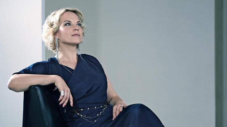 Dei Sängerin sitzt elegant auf einem edlen Ledersessel und schaut in die Höhe. Dei Sängerin sitzt elegant auf einem edlen Ledersessel und schaut in die Höhe.