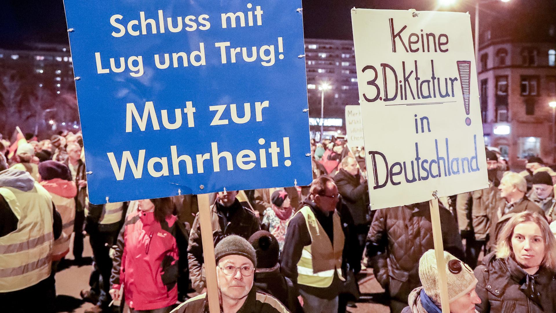 Unterstützer der Partei Alternative für Deutschland in Thüringen halten bei einer Demonstration der AfD in Erfurt Slogans auf Schildern in die Höhe. Unterstützer der Partei Alternative für Deutschland in Thüringen halten bei einer Demonstration der AfD in Erfurt Slogans auf Schildern in die Höhe.