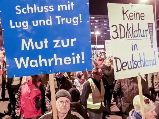 Unterstützer der Partei Alternative für Deutschland in Thüringen halten bei einer Demonstration der AfD in Erfurt Slogans auf Schildern in die Höhe.
