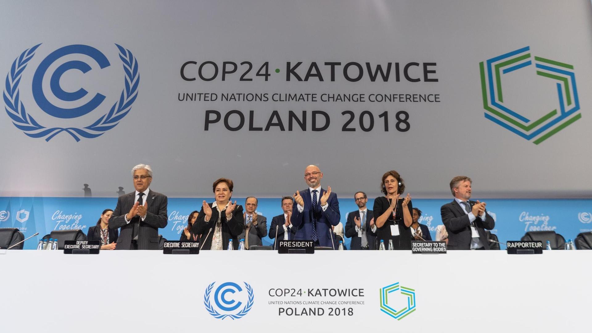 15.12.2018, Polen, Katowice: Michal Kurtyka (M), Präsident der UN-Klimakonferenz COP24, und weitere Teilnehmer des Klimagipfels freuen sich über den Beschluss des Kompromisses beim Weltklimagipfel. 15.12.2018, Polen, Katowice: Michal Kurtyka (M), Präsident der UN-Klimakonferenz COP24, und weitere Teilnehmer des Klimagipfels freuen sich über den Beschluss des Kompromisses beim Weltklimagipfel.