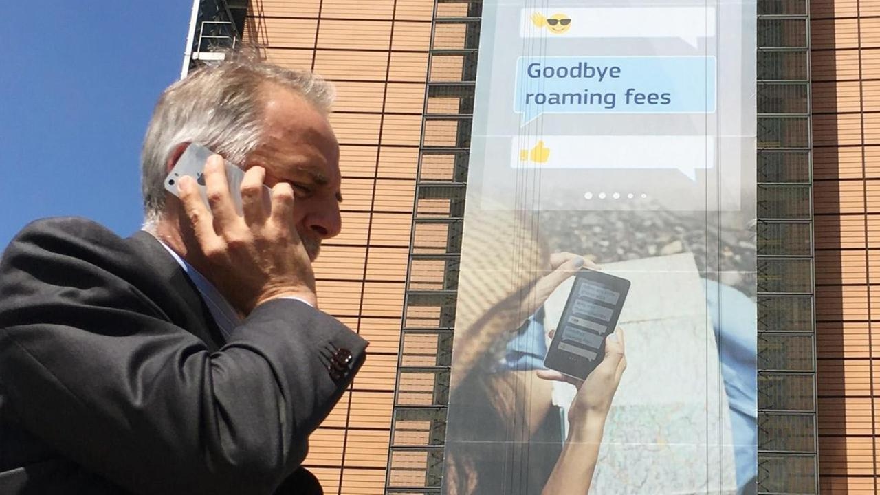 Mann telefoniert vor Hochhaus mit seinem Smartphone Mann telefoniert vor Hochhaus mit seinem Smartphone