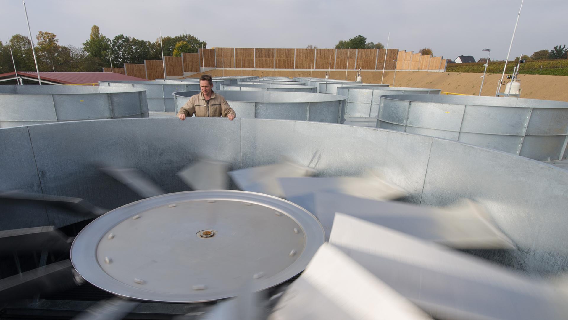 Ein Mitarbeiter steht in Insheim (Rheinland-Pfalz) in einem Geothermiekraftwerk neben einem großen Ventilator. Ein Mitarbeiter steht in Insheim (Rheinland-Pfalz) in einem Geothermiekraftwerk neben einem großen Ventilator.