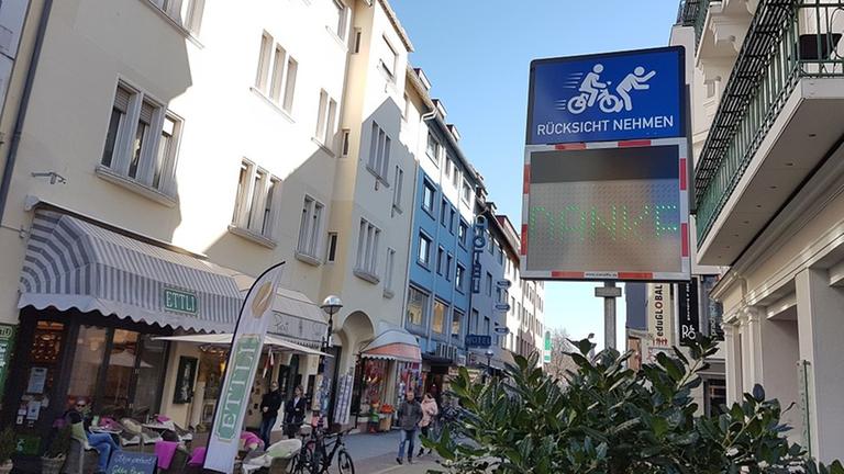 In der Karlsruher Fußgängerzone ermahnt ein Schild Radfahrer, langsam zu fahren In der Karlsruher Fußgängerzone ermahnt ein Schild Radfahrer, langsam zu fahren