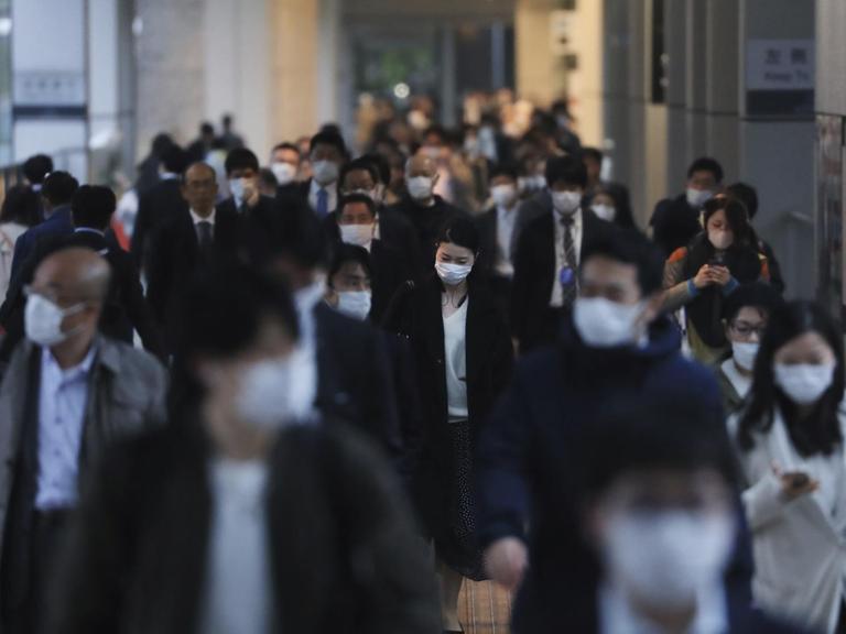 Menschen mit Masken in der Shinagwa Station in Tokio.