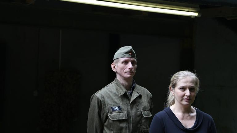 Die Besitzerin des Bunkerareals, Kathleen Höhn und einer ihrer Mitarbeiter in NVA-Uniform. 