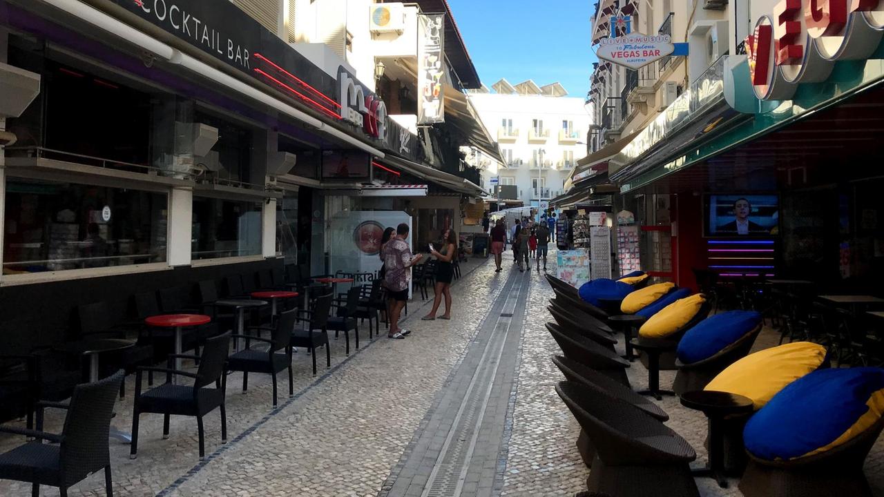 Eine Gasse mit Bars und Restaurants mit wenig Menschen. Eine Gasse mit Bars und Restaurants mit wenig Menschen.