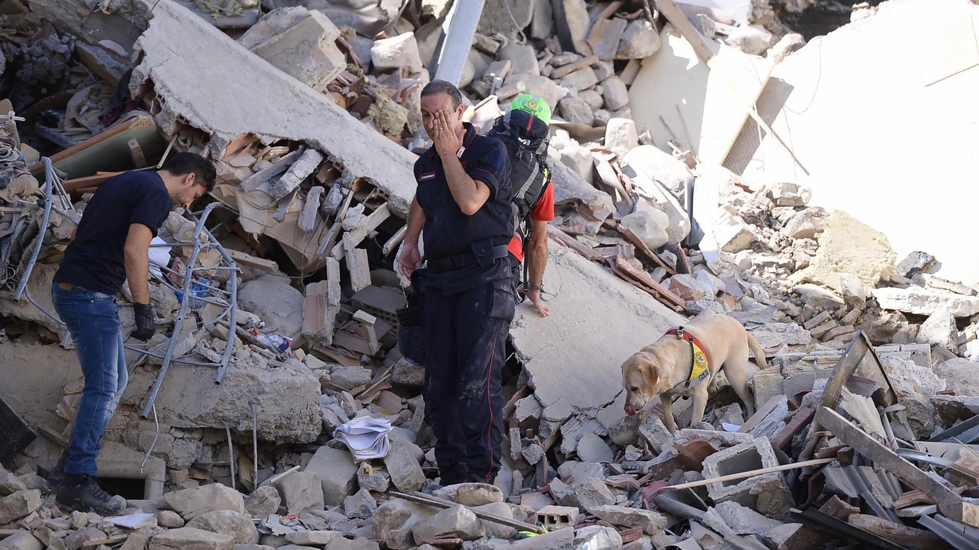 Helfer suchen in den Trümmern eines Gebäudes in Amatrice in Italien nach Überlebenden des Erdbebens. Helfer suchen in den Trümmern eines Gebäudes in Amatrice in Italien nach Überlebenden des Erdbebens.