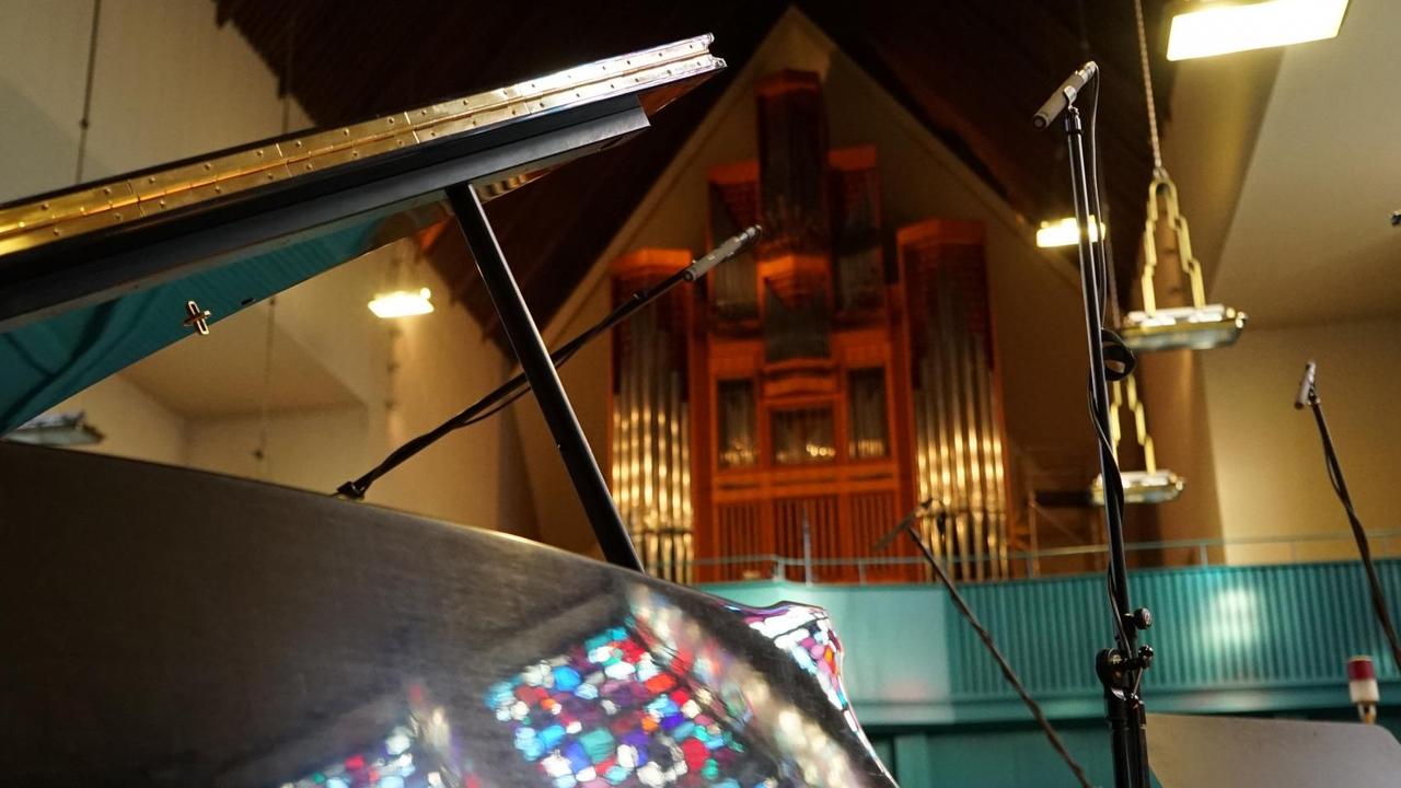 Ein Flügel in einer Kirche, im Hintergrund ist eine Orgel sichtbar. Ein Flügel in einer Kirche, im Hintergrund ist eine Orgel sichtbar.