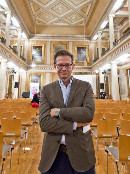 Bestsellerautor Florian steht in der festlichen Aula am Wilhelmsplatz, aufgenommen beim Göttinger Literaturherbst 2017