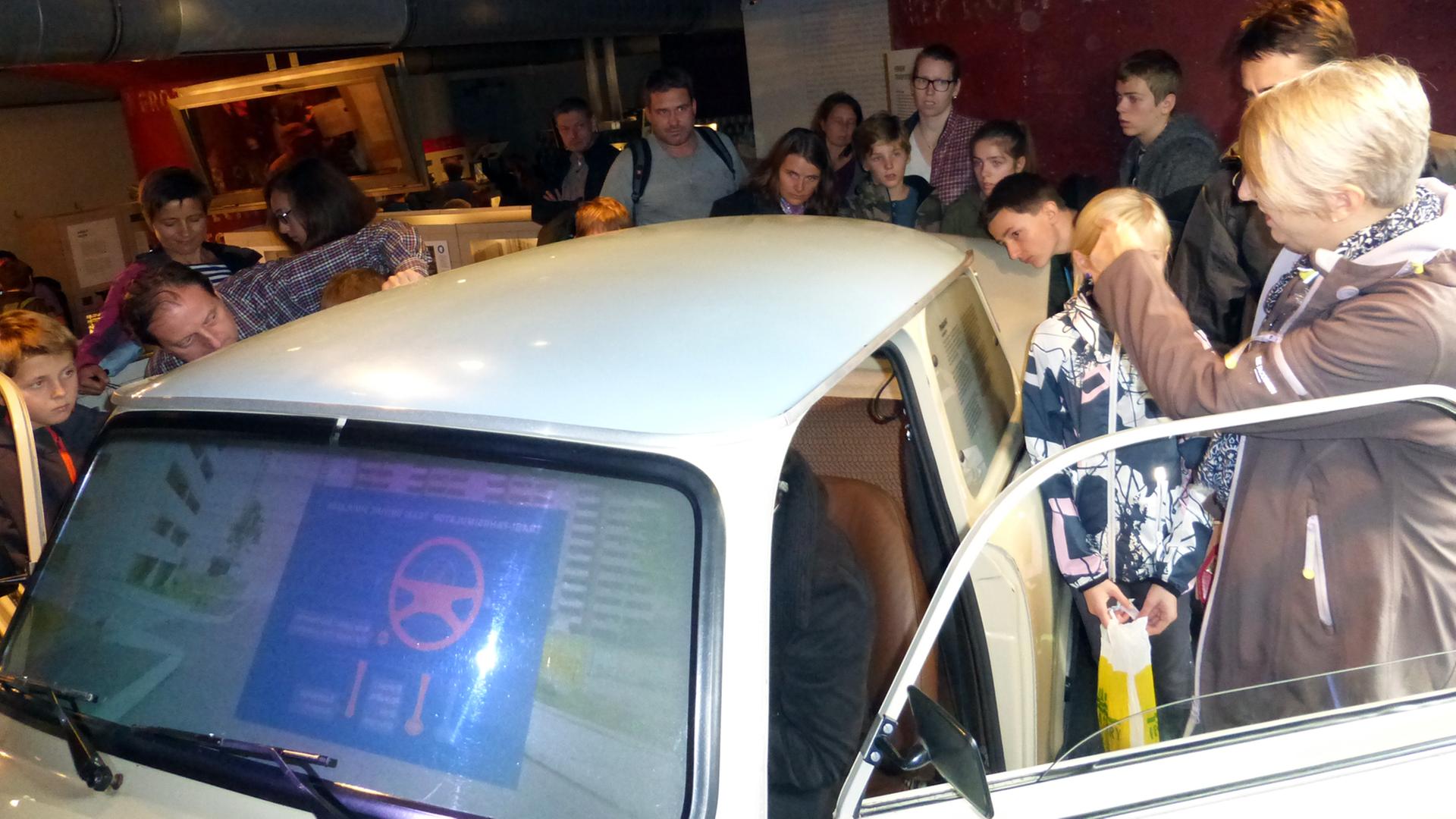 Eine Besuchergruppe umringt neugierig einen Trabant mit Fahrsimulator im DDR-Museum in Berlin. Er erlaubt eine virtuelle Fahrt durch eine Berliner Plattenbausiedlung. Eine Besuchergruppe umringt neugierig einen Trabant mit Fahrsimulator im DDR-Museum in Berlin. Er erlaubt eine virtuelle Fahrt durch eine Berliner Plattenbausiedlung.