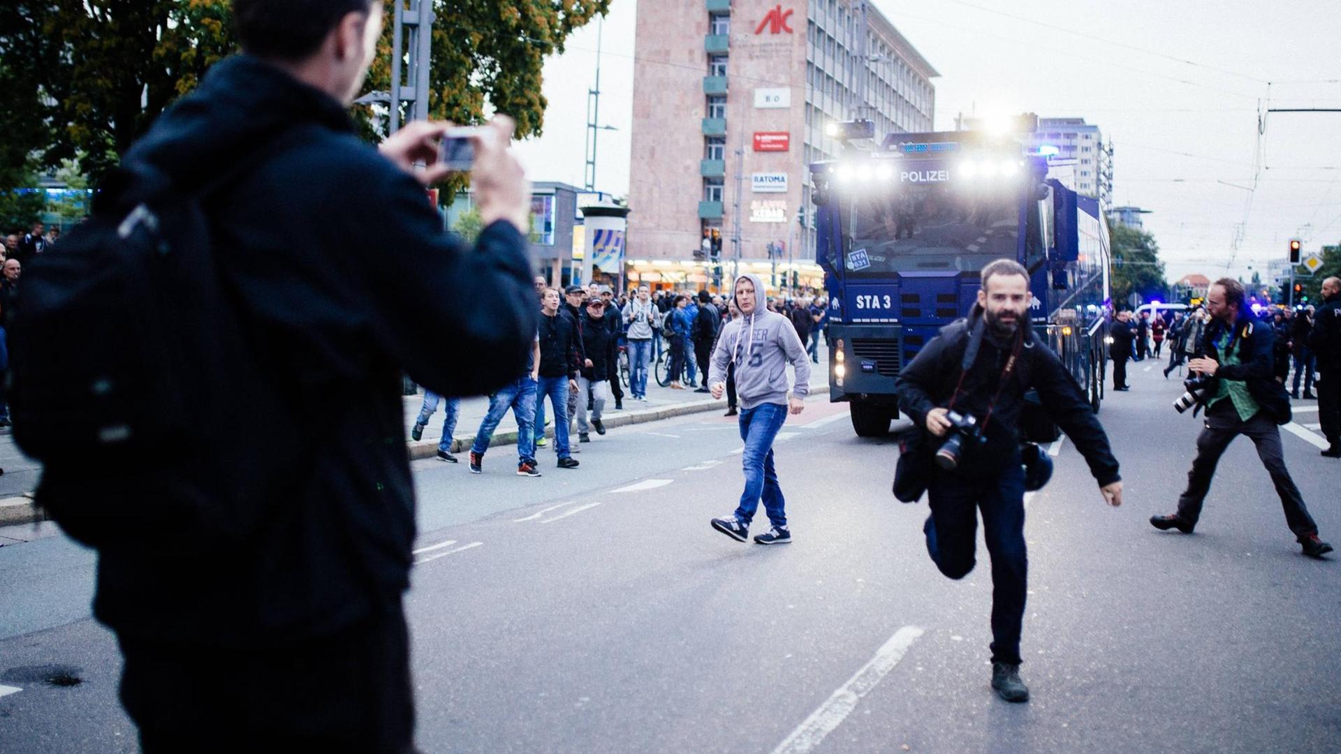 Ein Journalist flüchtet vor den Angriffen von rechten Demonstrationsteilnehmern beim Schweigemarsch von AfD und Pegida in Chemnitz. Ein Journalist flüchtet vor den Angriffen von rechten Demonstrationsteilnehmern beim Schweigemarsch von AfD und Pegida in Chemnitz.