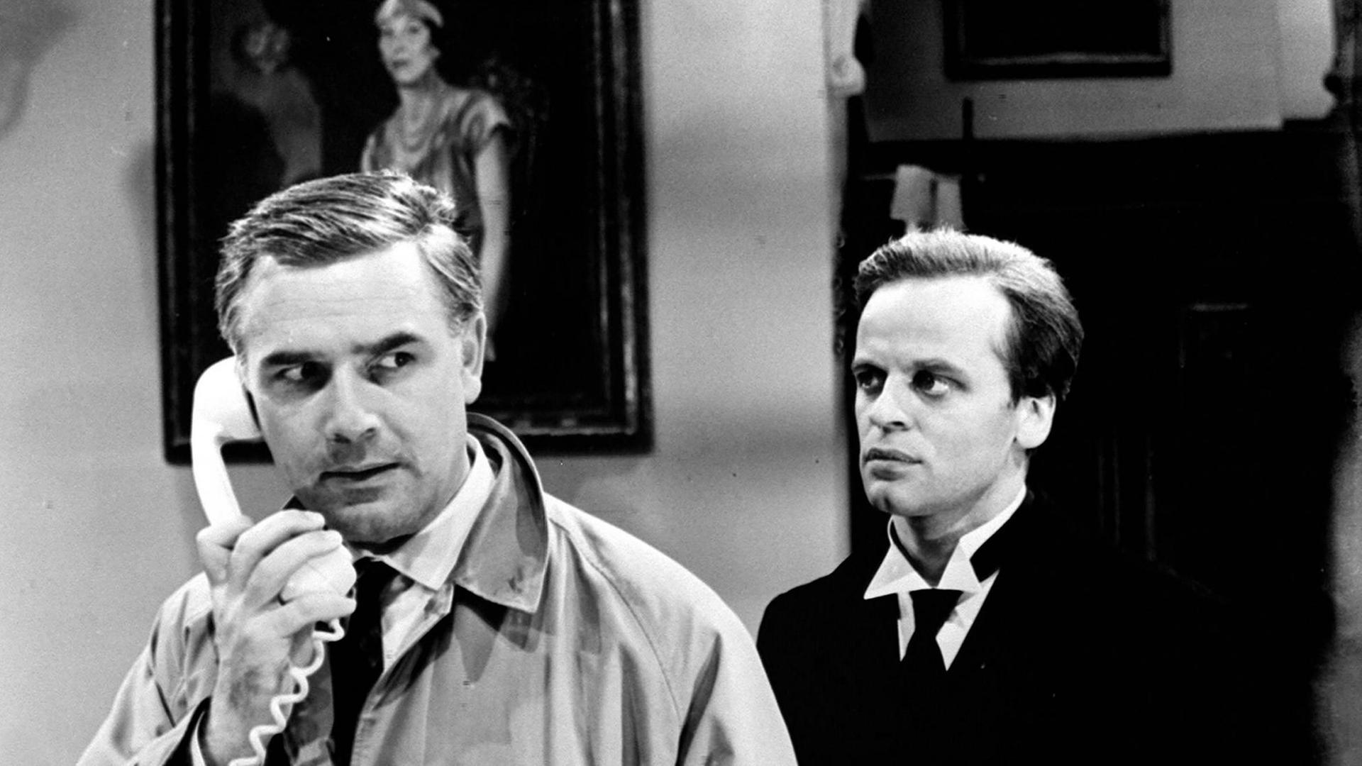Filmstill aus "Edgar Wallace: Der Schwarze Abt": Joachim Fuchsberger telefoniert, im Hintergrund Klaus Kinski. Filmstill aus "Edgar Wallace: Der Schwarze Abt": Joachim Fuchsberger telefoniert, im Hintergrund Klaus Kinski.