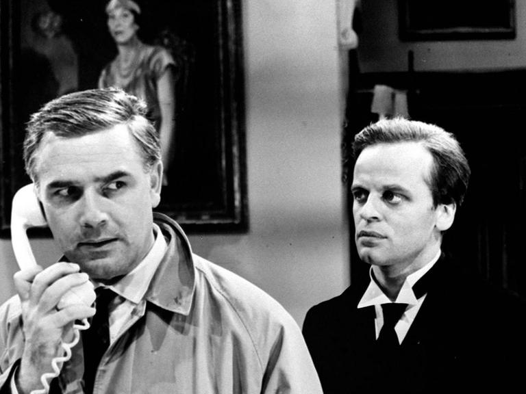 Filmstill aus "Edgar Wallace: Der Schwarze Abt": Joachim Fuchsberger telefoniert, im Hintergrund Klaus Kinski.