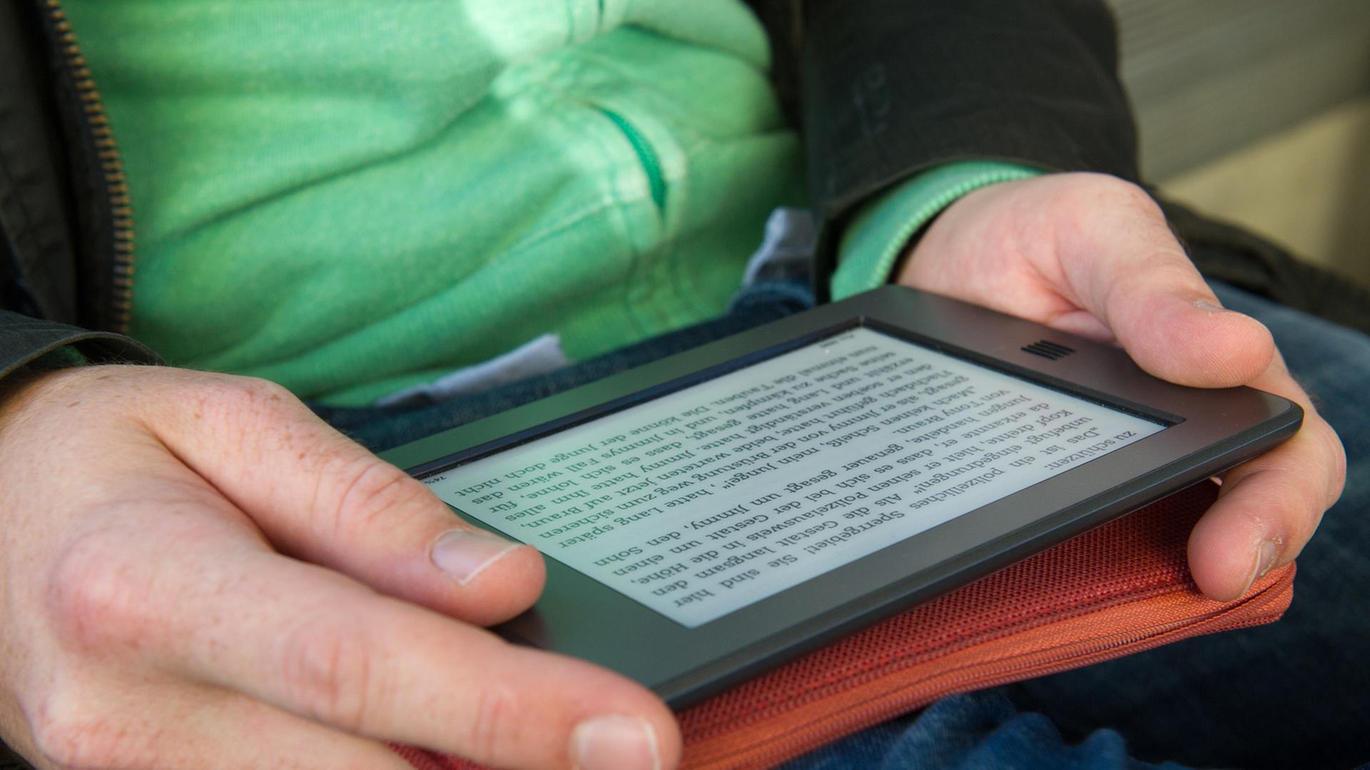 Ein Mann hält am 28.09.2012 in München (Bayern) ein elektronischen Reader der Marke Kindle in seinen Händen.