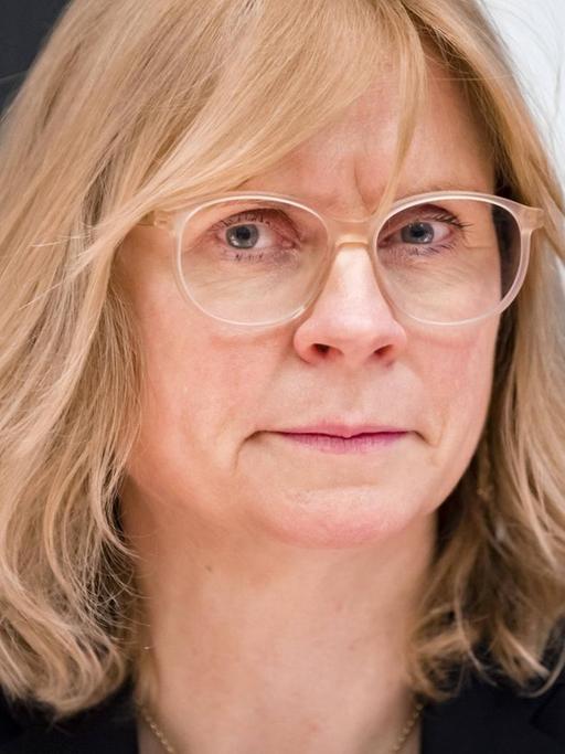 Blonde Frau mit Pagenschnitt und großer Brille