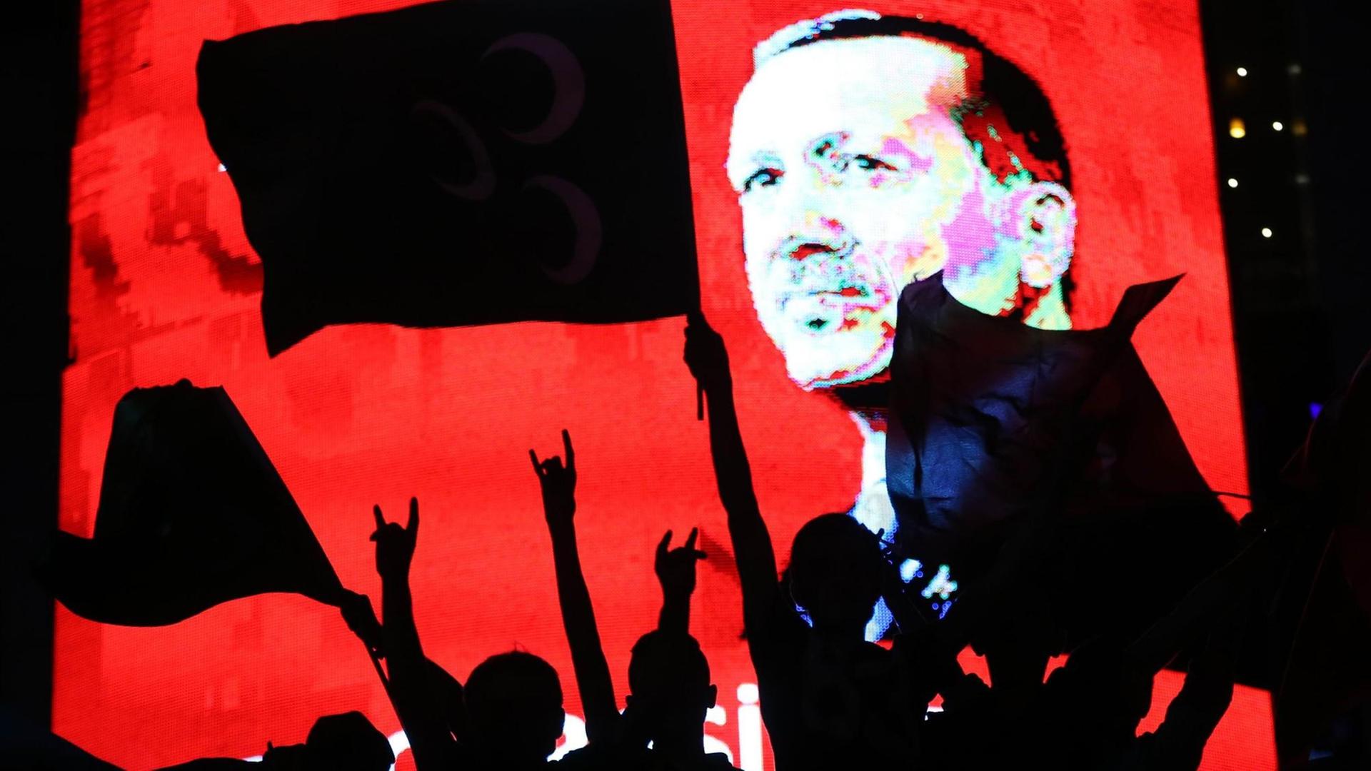 Erdogan-Anhänger mit Fahnen, im Hintergrund Porträt von Erdogan auf einem Bildschirm Erdogan-Anhänger mit Fahnen, im Hintergrund Porträt von Erdogan auf einem Bildschirm