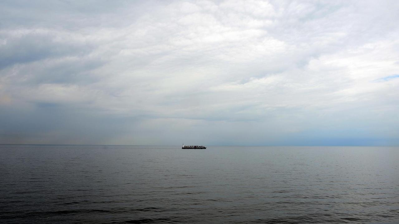 Die Ostsee vor Travemünde. Am Horizont ist ein Frachtschiff zu sehen.