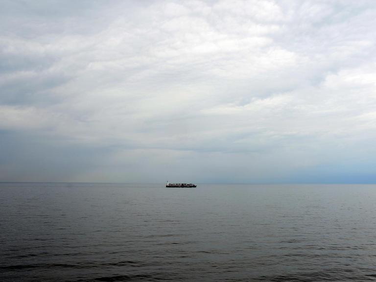Die Ostsee vor Travemünde. Am Horizont ist ein Frachtschiff zu sehen.
