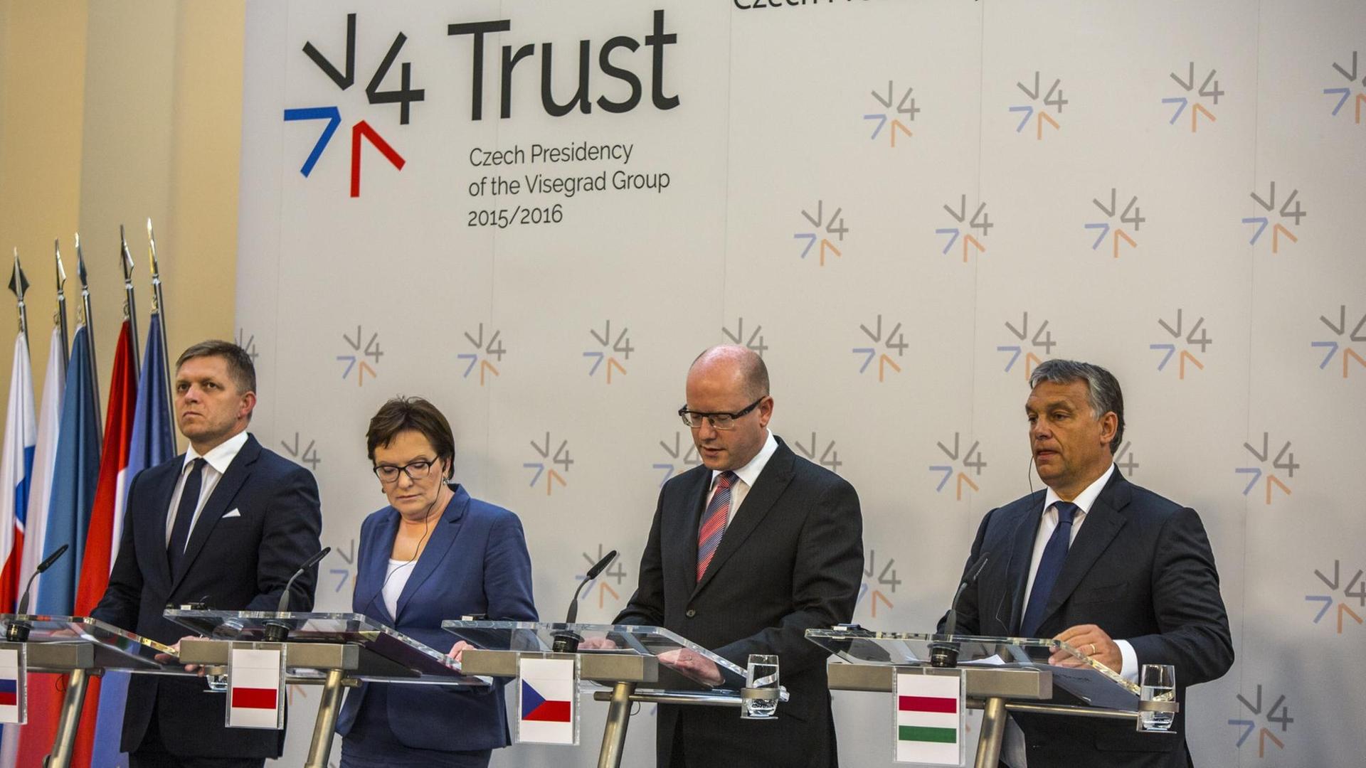 Der slowakische Premierminister Robert Fico, Polens Premierministerin Ewa Kopacz, der tschechische Premierminister Bohuslav Sobotka und der ungarische Premierminister Viktor Orban stehen in einer Reihe nebeneinander an Mikrofonen. Der slowakische Premierminister Robert Fico, Polens Premierministerin Ewa Kopacz, der tschechische Premierminister Bohuslav Sobotka und der ungarische Premierminister Viktor Orban stehen in einer Reihe nebeneinander an Mikrofonen.