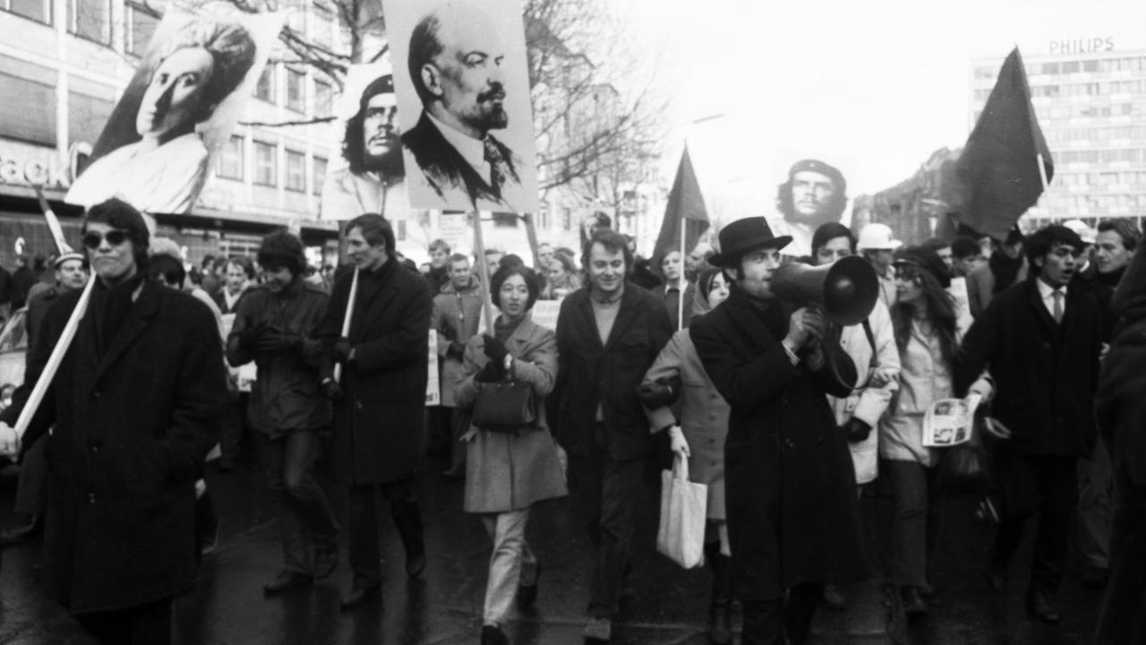 Schwarz-weiß-Fotografie von 1968: Sie zeigt Studenten während einer Demonstration, die Schilder mit den Porträts von Lenin, Che Guevara und Rosa Luxemburg in die Höhe halten. Schwarz-weiß-Fotografie von 1968: Sie zeigt Studenten während einer Demonstration, die Schilder mit den Porträts von Lenin, Che Guevara und Rosa Luxemburg in die Höhe halten.