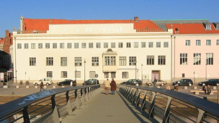 Ein historischer Gebäudekomplex mit hellem Anstrich und rotem Dach. Ein historischer Gebäudekomplex mit hellem Anstrich und rotem Dach.