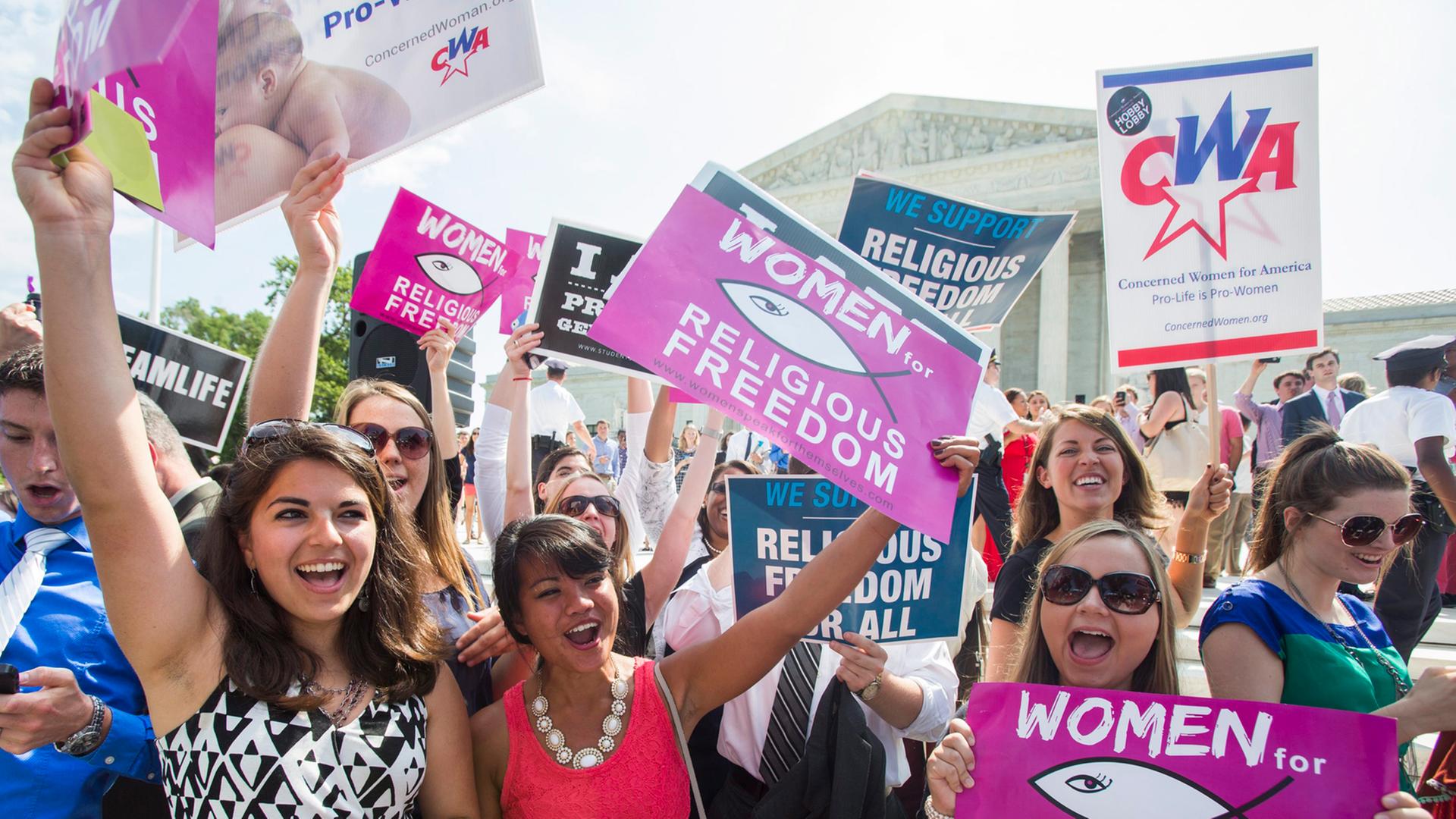 Abtreibungsgegner halten Plakate mit der Aufschrift "Women for religious freedom" vor dem Supreme Court, dem Obersten Gerichtshof in den USA. Abtreibungsgegner halten Plakate mit der Aufschrift "Women for religious freedom" vor dem Supreme Court, dem Obersten Gerichtshof in den USA.