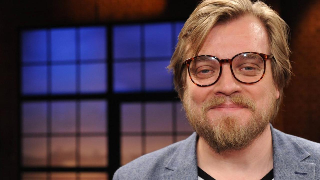 Porträtfoto von Nilz Bokelberg mit Brille und Bart. Porträtfoto von Nilz Bokelberg mit Brille und Bart.