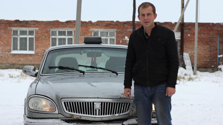 Der 31-jährige Taxifahrer Sergej vor seinem Wolga