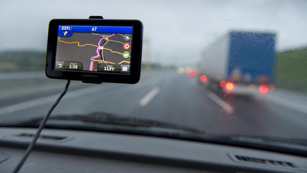 Ausblick auf eine Straße aus einer Windschutzscheibe mit Navigationsgerät Ausblick auf eine Straße aus einer Windschutzscheibe mit Navigationsgerät