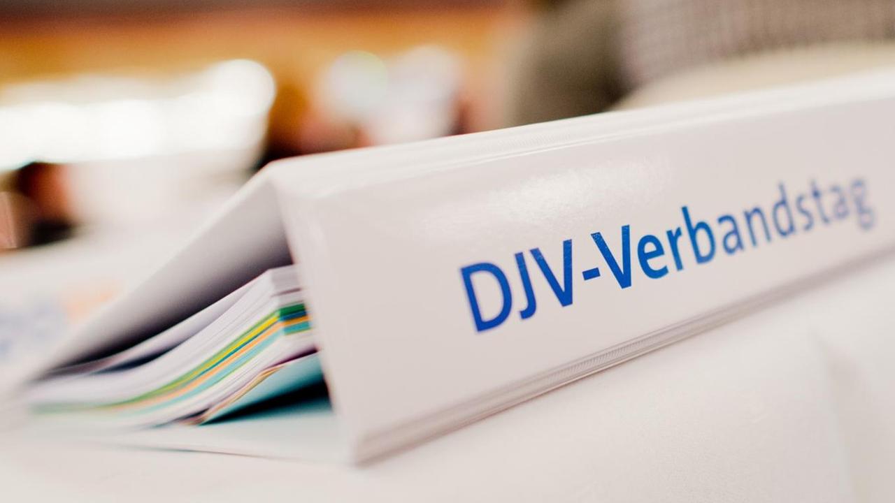 Ein Ordner des Verbandstags des Deutschen Journalisten-Verbandes (DJV) liegt auf einemTisch. Ein Ordner des Verbandstags des Deutschen Journalisten-Verbandes (DJV) liegt auf einemTisch.