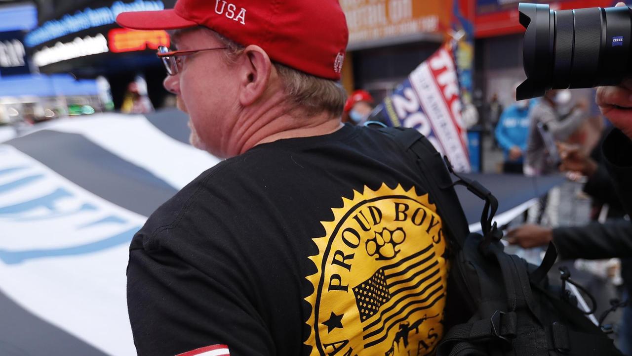 Ein Mitglied der Gruppierung "Proud Boys" hält eine Flagge und läuft auf der Fith Avenue in New York
Ein Mitglied der Gruppierung "Proud Boys" hält eine Flagge und läuft auf der Fith Avenue in New York