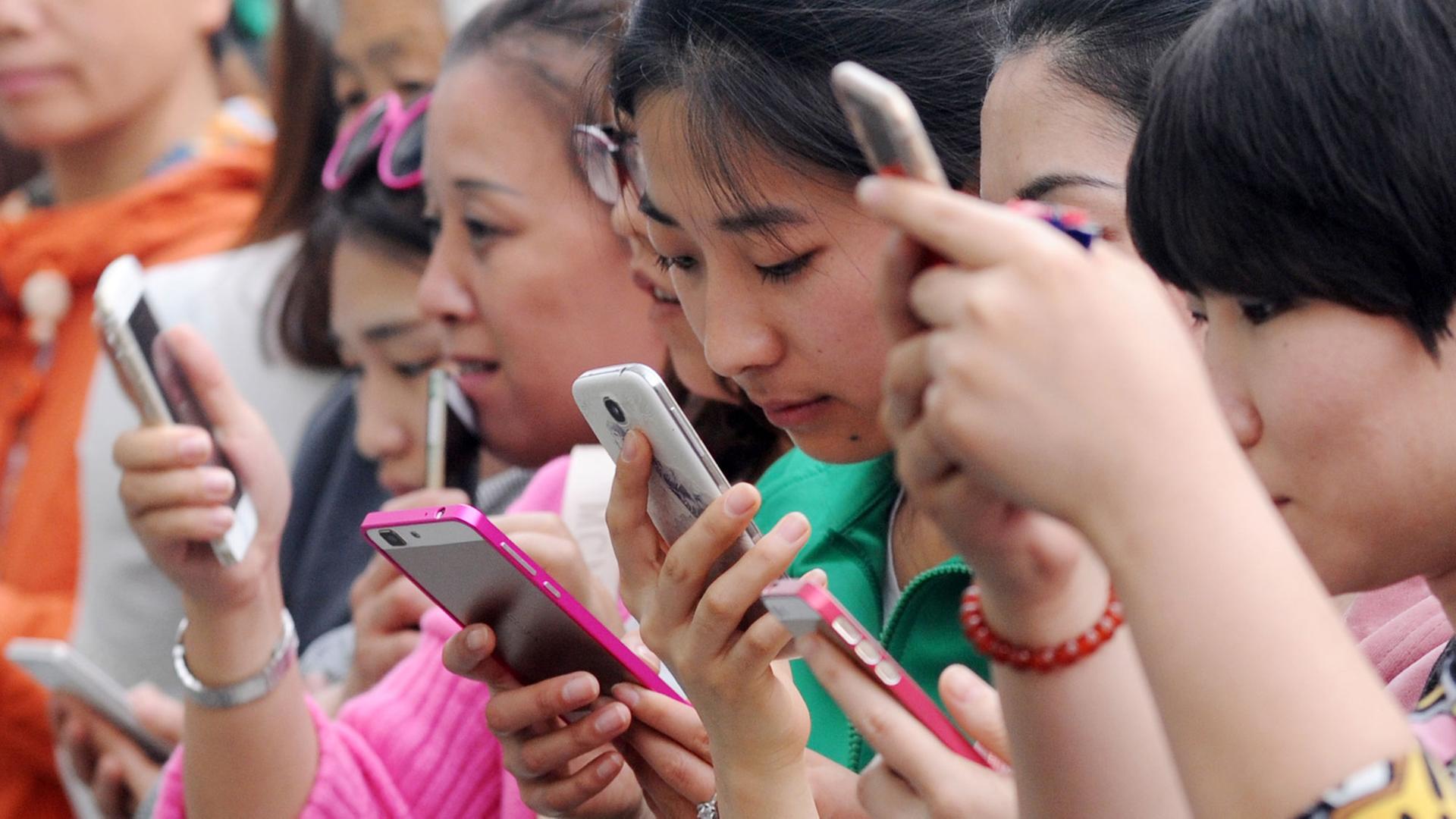 Junge Chinesinnen benutzen am 24.4.2015 ihre Smartphones für ein Gewinnspiel in einem Einkaufszentrum in Taiyuan im Norden Chinas. Junge Chinesinnen benutzen am 24.4.2015 ihre Smartphones für ein Gewinnspiel in einem Einkaufszentrum in Taiyuan im Norden Chinas.