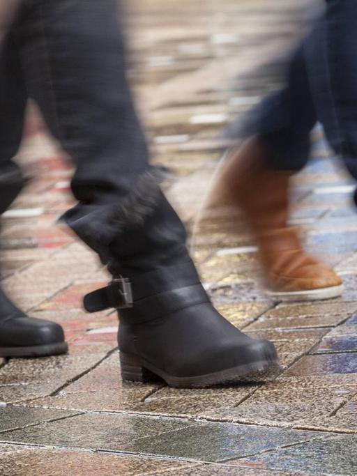 Aufnahme von Beinen und Schuhen zweiter Menschen in einer Fußgängerzone.