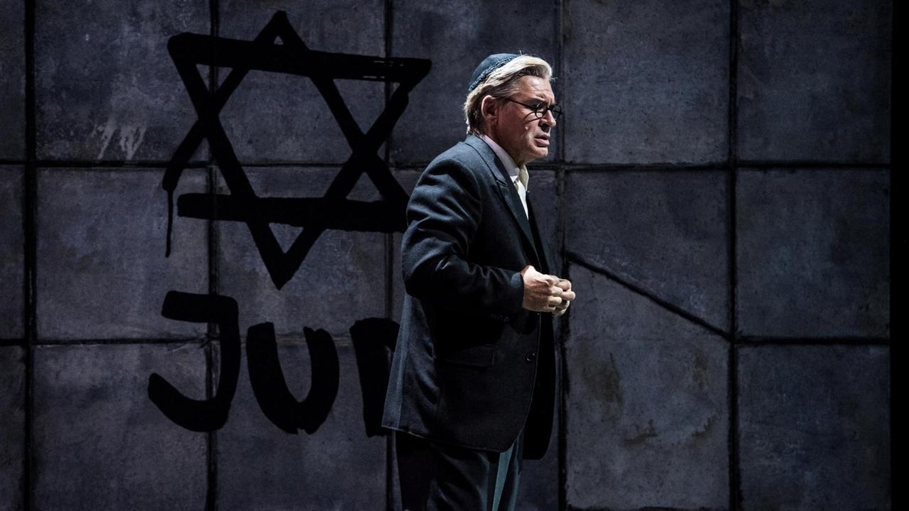 Ein Mann mit Kippa vor einer Mauer, auf die ein Davidstern und das Wort Jude geschrieben wurden. Ein Mann mit Kippa vor einer Mauer, auf die ein Davidstern und das Wort Jude geschrieben wurden.
