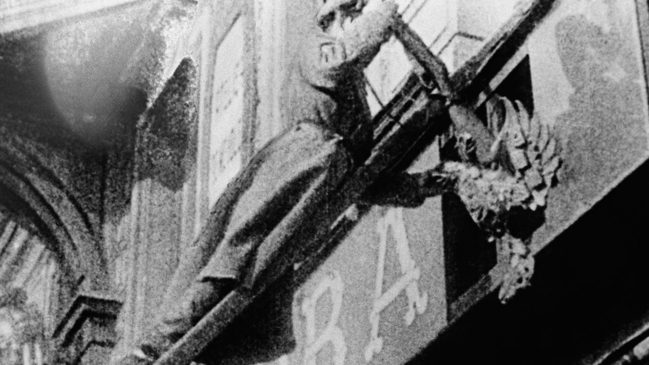 Februarrevolution 1917: Ein Soldat der Revolutionsstreitkräfte entfernt ein Emblem des Zarenreiches. Februarrevolution 1917: Ein Soldat der Revolutionsstreitkräfte entfernt ein Emblem des Zarenreiches.