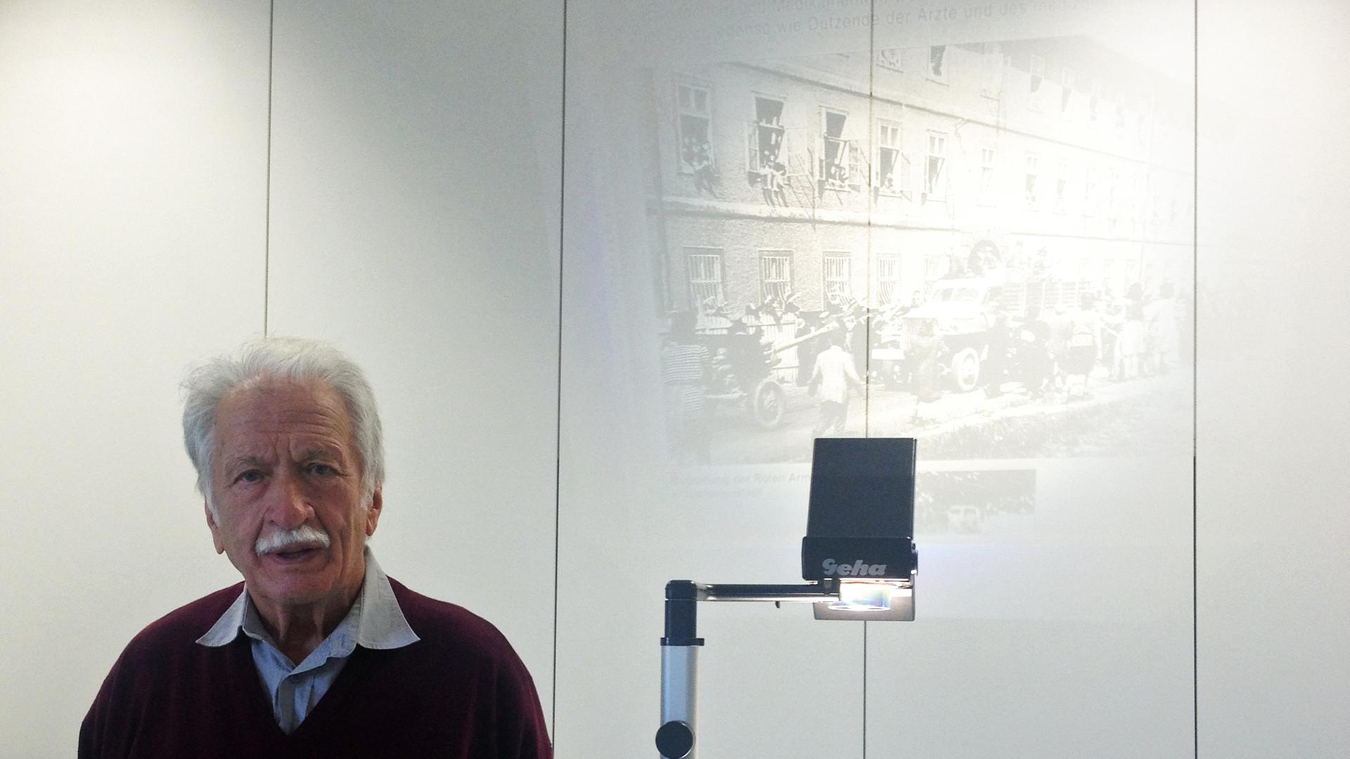 Der Holocaust-Überlebende Ernst Grube auf einem Bild (links) vor einem Overhead-Projektor mit einer Projektion, die an die Wand gestrahlt wird. Der Holocaust-Überlebende Ernst Grube auf einem Bild (links) vor einem Overhead-Projektor mit einer Projektion, die an die Wand gestrahlt wird.