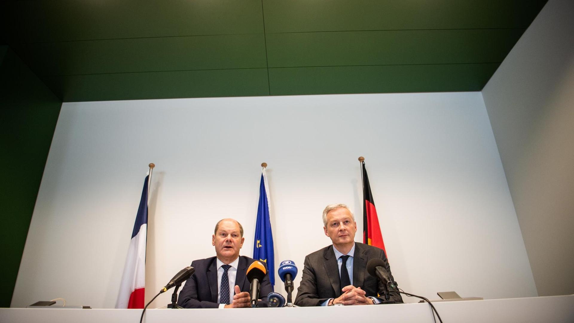 14.06.2019, Luxemburg: Olaf Scholz (SPD, l), Bundesfinanzminister und Bruno Le Maire (r), Wirtschaftsminister von Frankreich, geben nach dem Eurogruppentreffen eine gemeinsame Pressekonferenz. Bei dem Treffen haben in der Nacht zu Freitag die Finanzminister der Euroländer Fortschritte beim umstrittenen Eurozonenbudget erzielt. Foto: Arne Immanuel Bänsch/dpa | Verwendung weltweit 14.06.2019, Luxemburg: Olaf Scholz (SPD, l), Bundesfinanzminister und Bruno Le Maire (r), Wirtschaftsminister von Frankreich, geben nach dem Eurogruppentreffen eine gemeinsame Pressekonferenz. Bei dem Treffen haben in der Nacht zu Freitag die Finanzminister der Euroländer Fortschritte beim umstrittenen Eurozonenbudget erzielt. Foto: Arne Immanuel Bänsch/dpa | Verwendung weltweit
