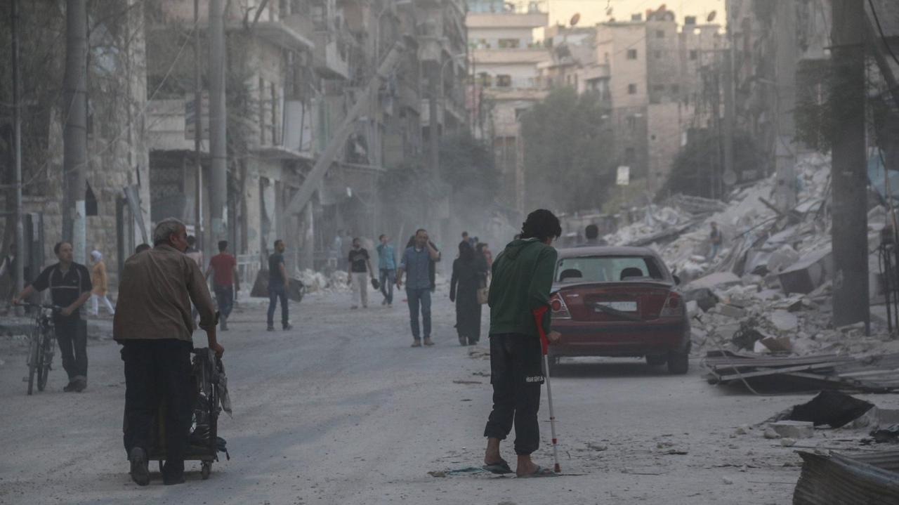 Menschen in Aleppo auf der Straße mitten in Trümmern. 