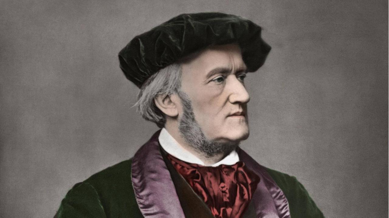 Nachkoloriertes Foto des Komponisten von 1871 von Franz Hanfstaengl auf dem Richard Wagner eine rötliche Mütze und einen wertvollen, schweren Mantelumhang trägt.