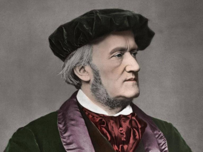 Nachkoloriertes Foto des Komponisten von 1871 von Franz Hanfstaengl auf dem Richard Wagner eine rötliche Mütze und einen wertvollen, schweren Mantelumhang trägt.