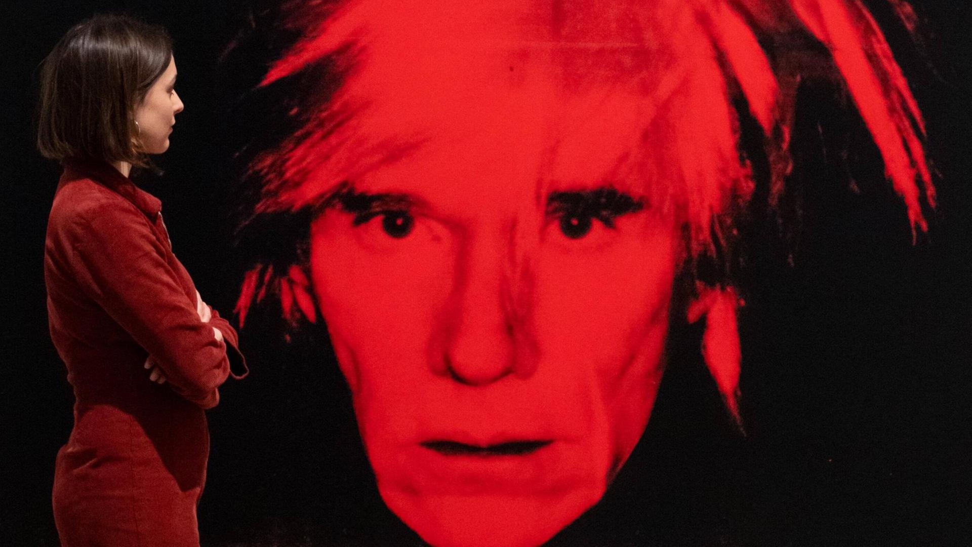 Eine Mitarbeiterin der Tate Modern Gallery betrachtet das Werk "Self Portrait" von Andy Warhol. Eine Mitarbeiterin der Tate Modern Gallery betrachtet das Werk "Self Portrait" von Andy Warhol.