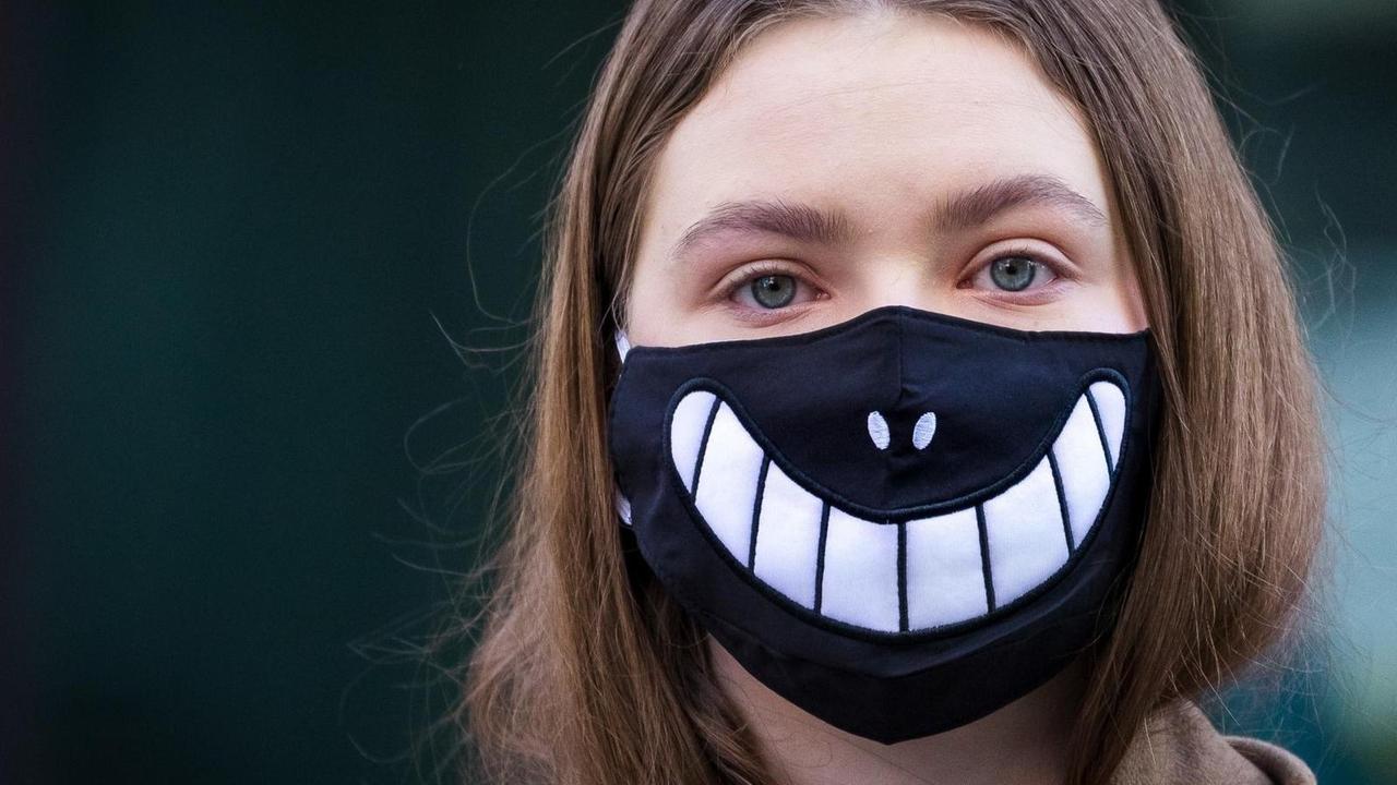 Ein Mädchen trägt eine Halloween-Maske vor dem Gesicht, als Schutz vor dem Corona Virus. London, 16. März 2020 Ein Mädchen trägt eine Halloween-Maske vor dem Gesicht, als Schutz vor dem Corona Virus. London, 16. März 2020