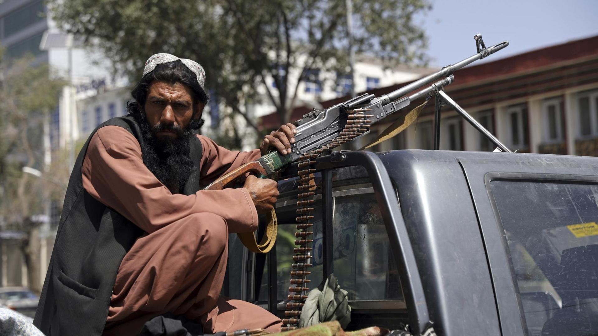 Afghanistan: Ein Talibankämpfer sitzt mit einem Gewehr auf einem Fahrzeug in Kabul. Afghanistan: Ein Talibankämpfer sitzt mit einem Gewehr auf einem Fahrzeug in Kabul.