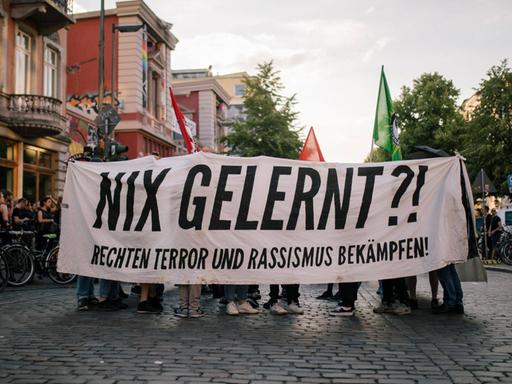 Teilnehmer einer Demo gegen rechten Terror in Hamburg tragen ein Transparent mit der Aufschrift "Nix gelernt?! Rechten Terror und Rassismus bekämpfen"