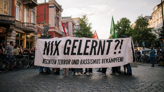 Teilnehmer einer Demo gegen rechten Terror in Hamburg tragen ein Transparent mit der Aufschrift "Nix gelernt?! Rechten Terror und Rassismus bekämpfen"