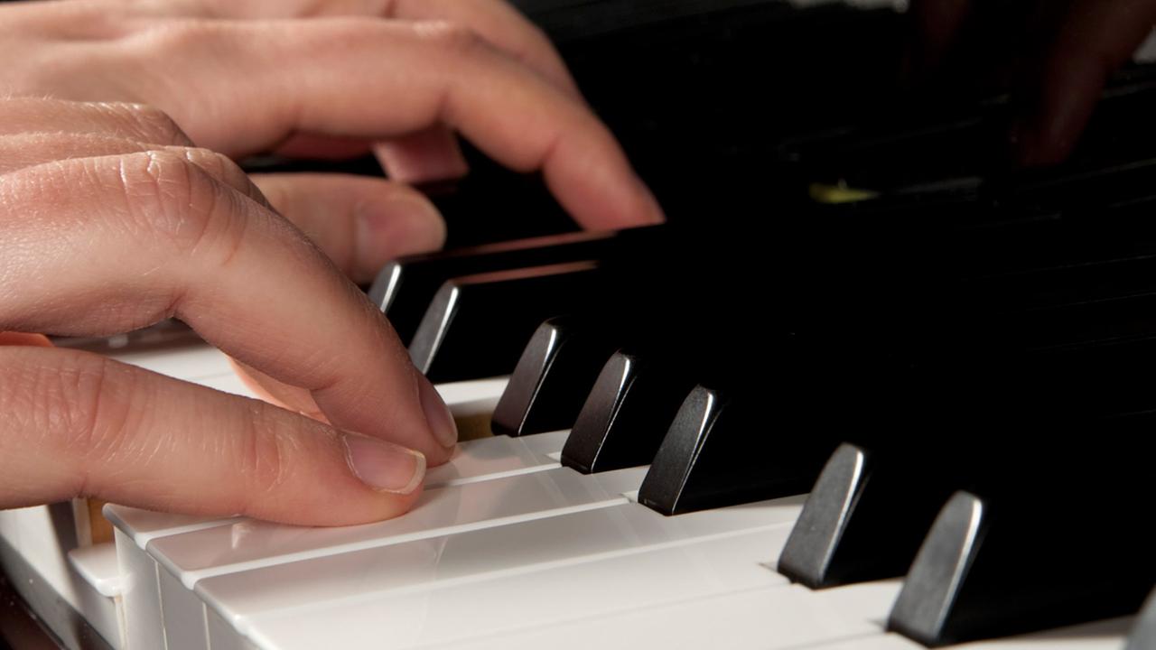 Frauenhaende druecken die Tasten eines Bechstein-Fluegels beim Klavierspiel. Frauenhaende druecken die Tasten eines Bechstein-Fluegels beim Klavierspiel.