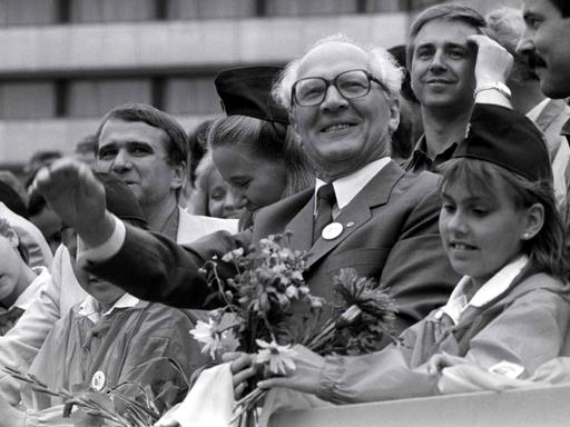 Erich Honecker (Mitte), Generalsekretär des ZK der SED und Vorsitzender des Staatsrates der DDR, Egon Krenz (l) und Eberhard Aurich (r) mit Pionieren auf der Ehrentribüne bei VIII. Pioniertreffen im August 1988 in Karl-Marx-Stadt.