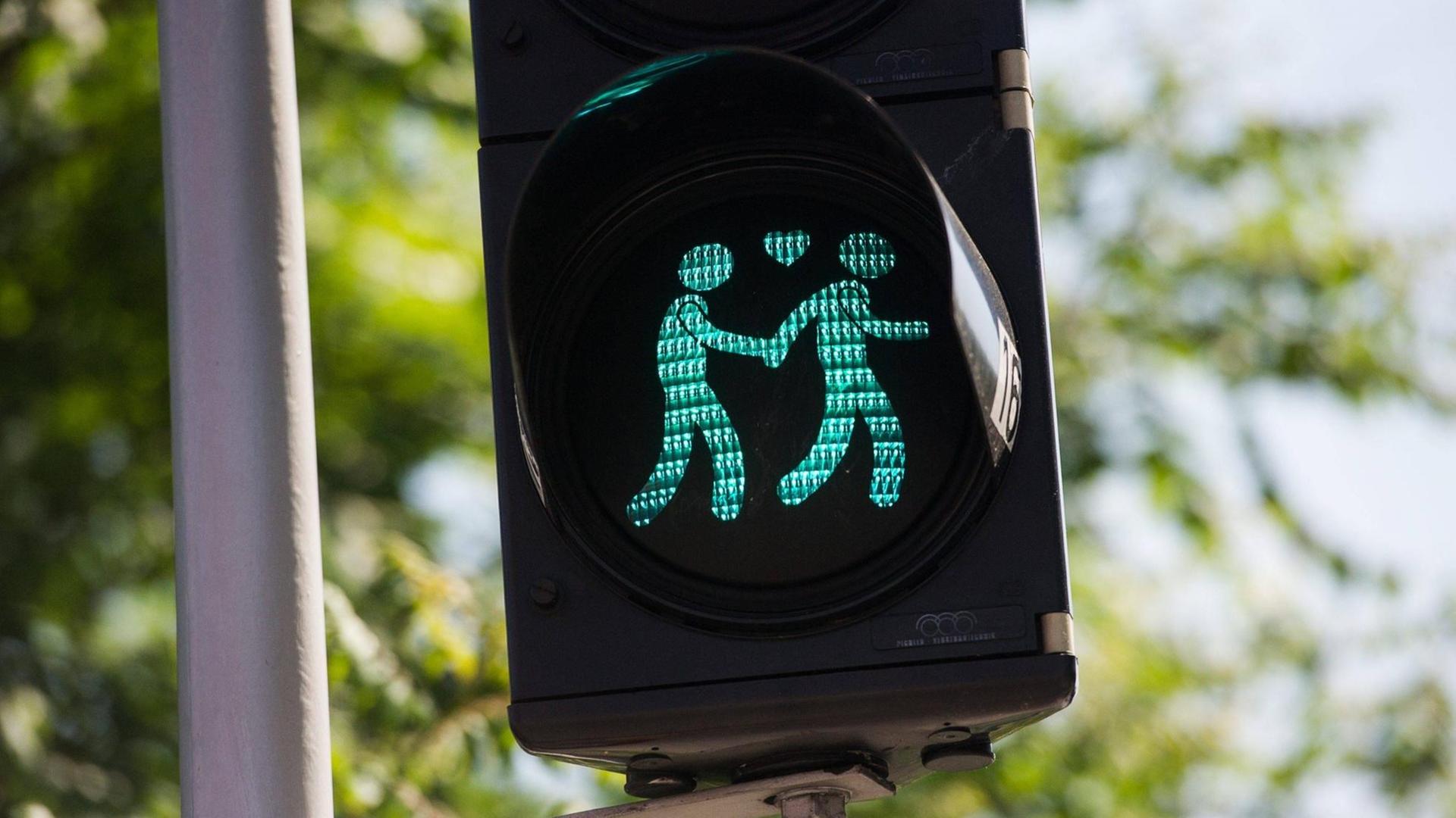 Eine grüne Ampel zeigt zwei Händchen haltende Männer. Eine grüne Ampel zeigt zwei Händchen haltende Männer.