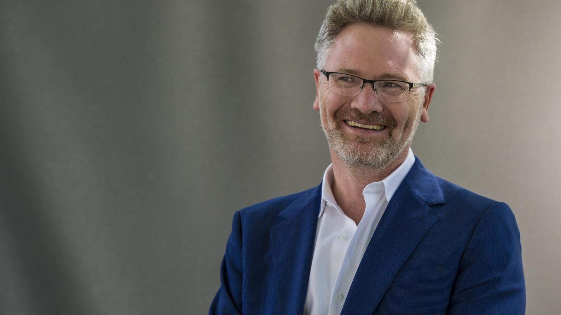 Der britische Wirtschaftshistoriker Adam Tooze lacht in die Kamera. Der britische Wirtschaftshistoriker Adam Tooze lacht in die Kamera.
